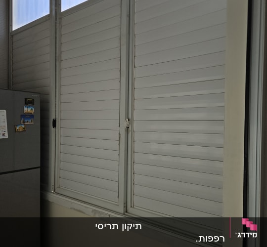 תריסים לבנים סגורים על חלון גדול